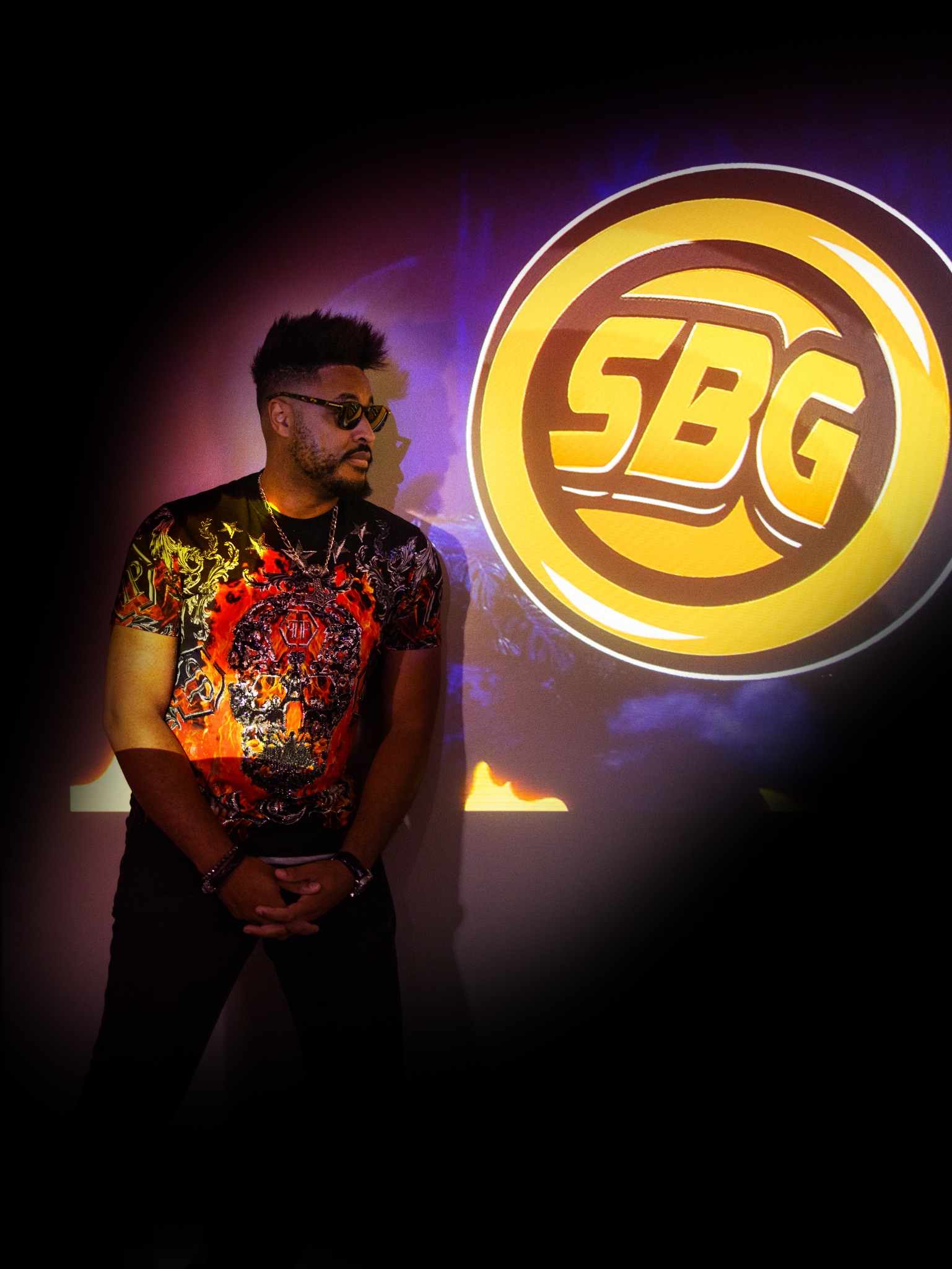 Walter Wright, founder of SBG Entertainment, standing beside the SBG logo